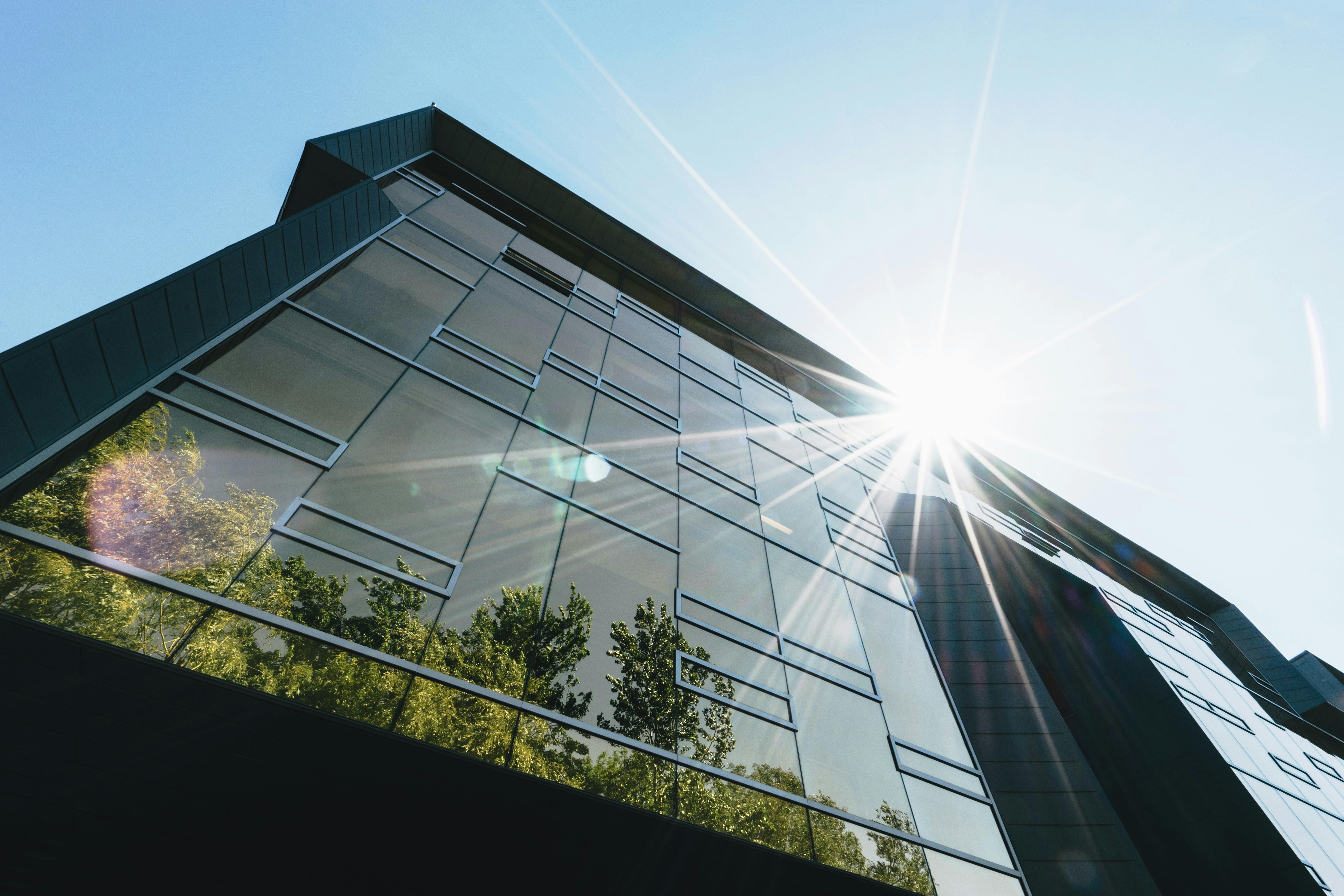 Modern high-performance building with glass facade reflecting trees